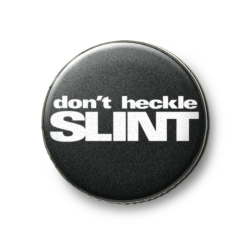 Don't Heckle Slint button, 1.25 inches, glow in the dark, white text on black background